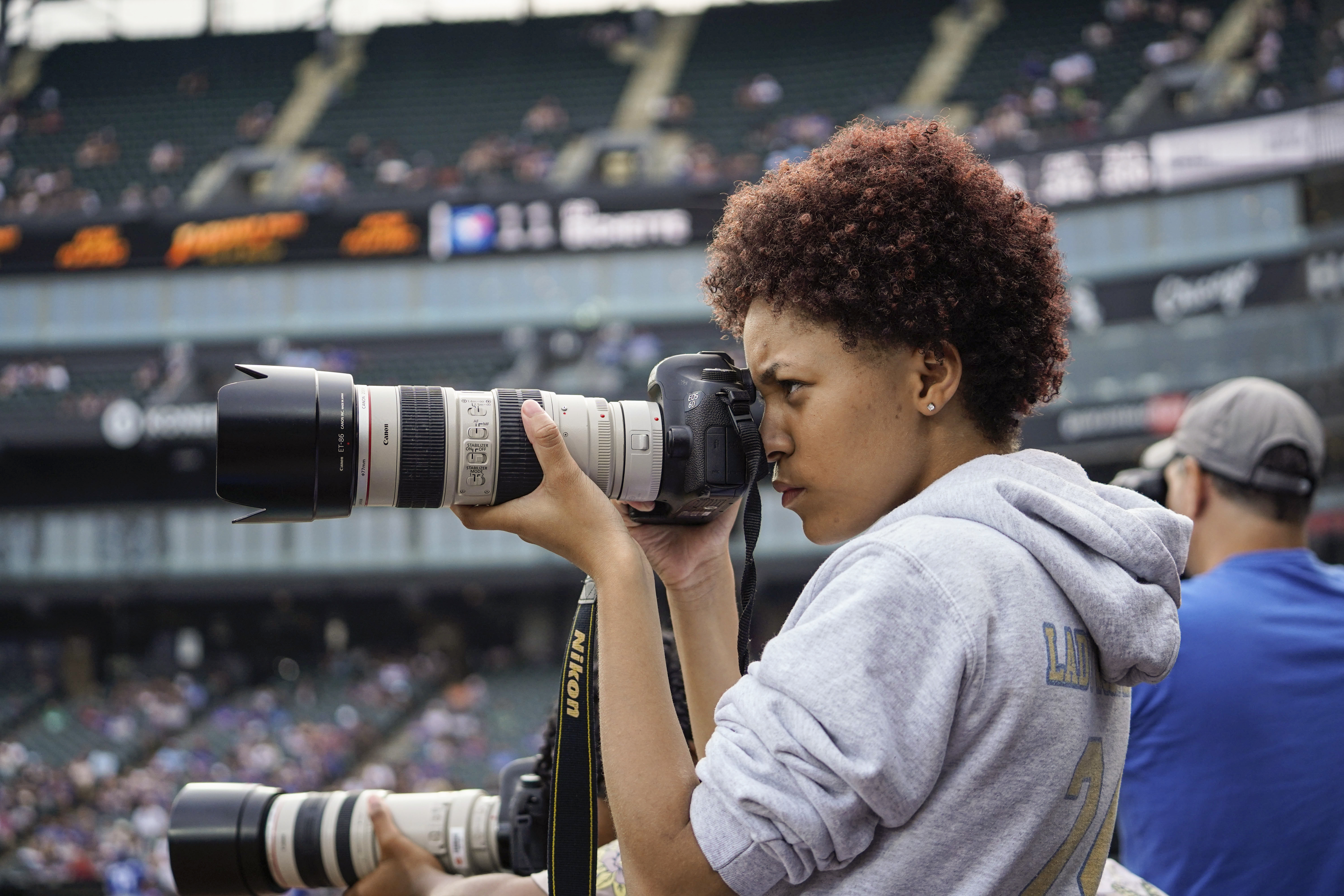 Young photographer takes photos at baseball game